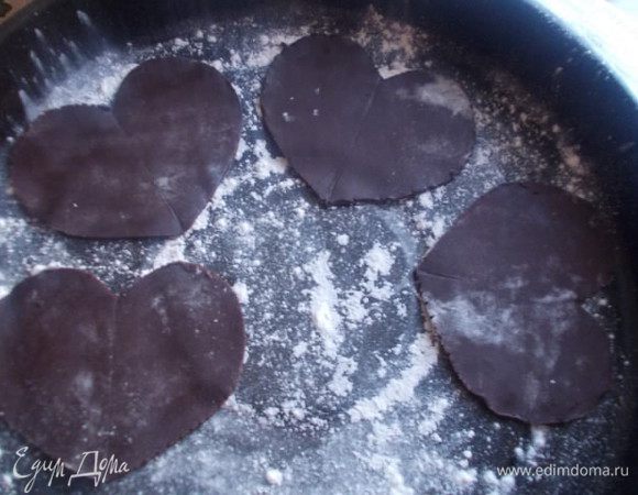 Раскатать тесто и вырезать с помощью ножа сердечки,выложить их на противень посыпанный мукой.