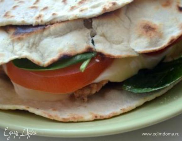 В горячую лепешку кладем горячее филе, сверху 2 кружка моцареллы, затем помидоры и посыпаем молодым шпинатом, накрываем второй половиной и подаем. 