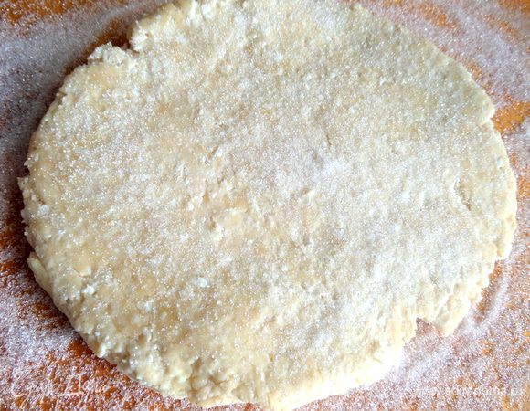 Кладём расплющенную лепёшку из теста,посыпаем сверху сахаром и начинаем раскатывать.