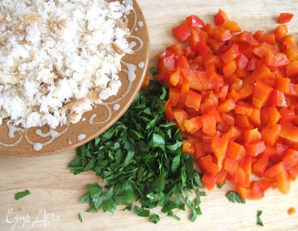 Перец помыть, разрезать на половинки, удалить семена, запечь в фольге,  охладить, порезать кубиками. Петрушку порезать. Подготовить хлебные крошки. Все это добавить в фарш, туда же положить желток, посолить, поперчить, перемешать. Взвесить начинку.