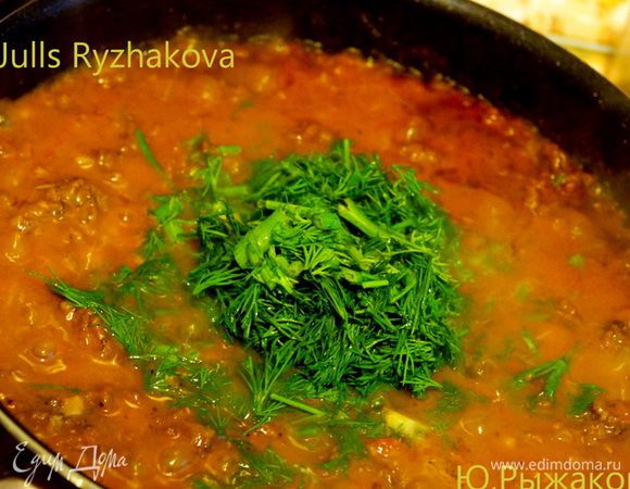 Добавляем натертые помидоры, томатную пасту и вино на сковороду. Перемешиваем. Добавляем мелко порубленную зелень.