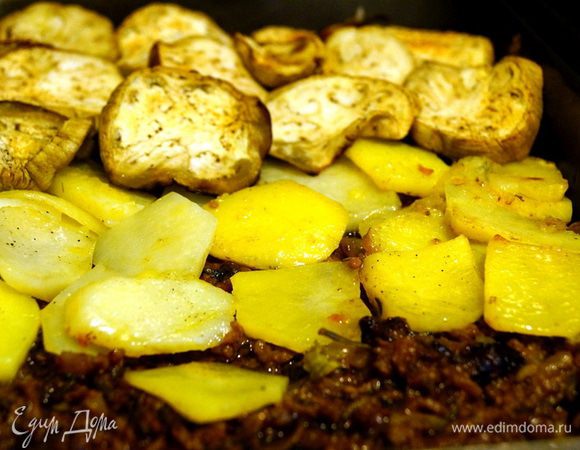 Берем форму, в которой будем запекать нашу мусаку. Советую взять форму с более высокими краями. Смазываем дно маслом, посыпаем панировочные сухари. Затем выкладываем слои: болоньезе, картофель, баклажаны, болоньезе, картофель, баклажаны, болоньезе.
Картофель и баклажаны мы предварительно запекли в духовке (см. Шаг 1).