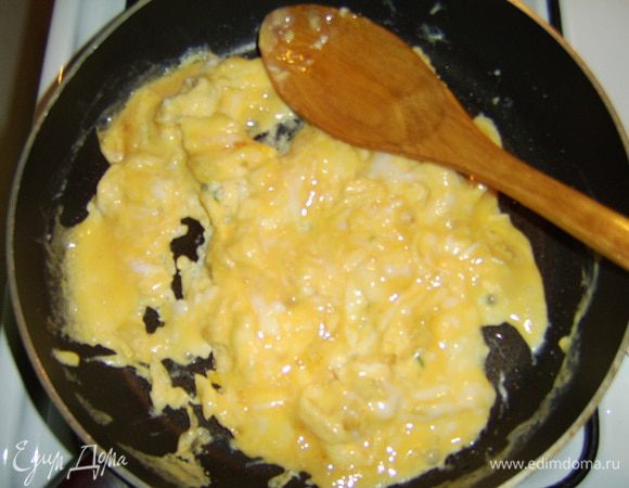 В это время чеснок раздавить или мелко порезать, обжарить до золотистого цвета  на оливковом масле, добавить взбитые яйца (3-4 штуки) и пожарить как обычную яичницу до полуготовности. 