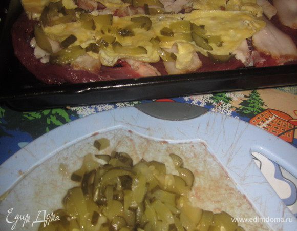 Соленый огурец нарезать тонкой соломкой и выложить верхним слоем.