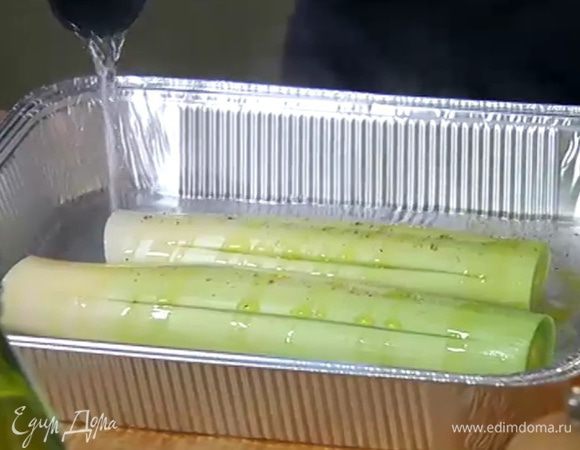 Выложить порей в глубокую форму, посолить, поперчить, сбрызнуть оливковым маслом, влить в форму горячую воду, чтобы лук на треть был погружен в жидкость.