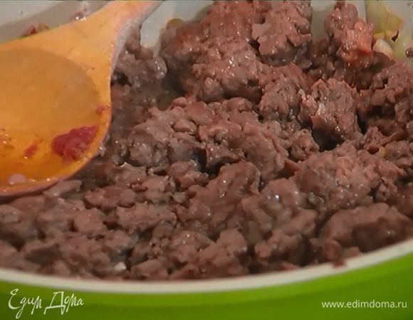 В сковороду с луком добавить мясной фарш и чеснок, слегка посолить, поперчить и перемешать. Обжаривать до готовности, разминая лопаткой комочки фарша.