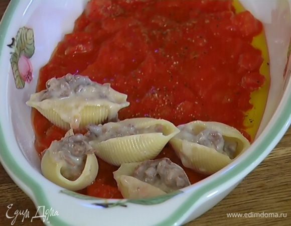 Отваренные ракушки наполнить фаршем с соусом и выложить в форму с томатами.