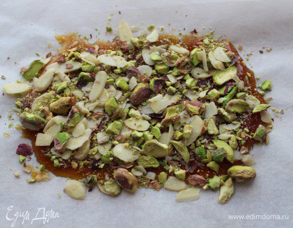 Вылить карамель на лист пергамента, сверху посыпать ореховой смесью и дать грильяжу  застыть. Застывший грильяж поломать на небольшие кусочки.