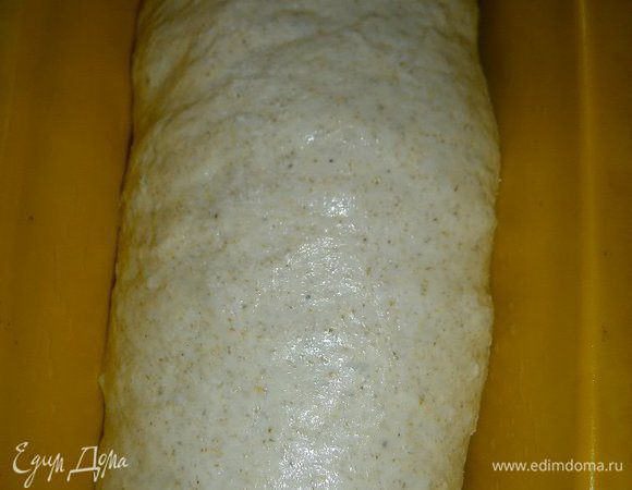 Подошедшее второй раз тесто выложить на слегка присыпанный мукой стол, слегка обмять ( но не мять тесто, чтобы не выпустить пузырьки воздуха), разделить на 2 части. Каждую часть растянуть руками и свернуть рулетом, выложить в формы швом вниз. Накрыть и дать расстояться в течении 1 часа.