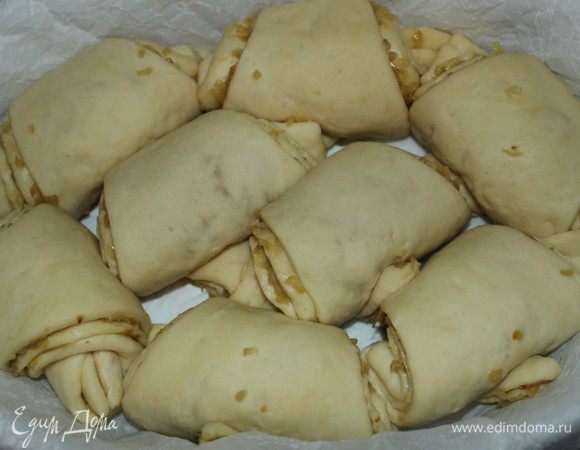 Каждую часть свернуть рулетом, начиная с широкой стороны. Форму для выпечки выстелить пергаментом или смазать маслом. Выложить рулеты в форму и оставить на 30 минут в теплом месте. 