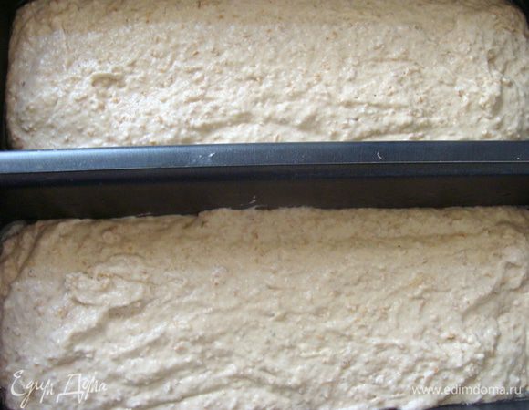 Добавить в закваску растительное масло, мед и соль, потом крупу, перемешать, затем добавить просеянную муку. Количество муки можно регулировать. Замесить тесто, разложить по формам. Форма наполнена до половины. Накрыть полотенцем и оставить в тепле, пока тесто не поднимется и не заполнит форму полностью.