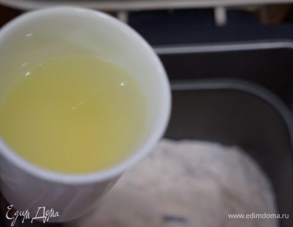 Отдельно в чашке соединяем лимонный сок, теплую воду и соль. Выливаем в хлебопечку. 