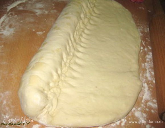 Затем свернуть тесто в рулет, но с небольшой тонкостью:
после каждого полного оборота теста при скатывании, прищипывать край рулета к пласту теста пальцами, и притом плотно.
И так надо сделать до конца свертывания всего рулета. При сворачивании не нужно скатывать тесто очень туго, и в то же время не нужно допускать пустот между слоями теста.