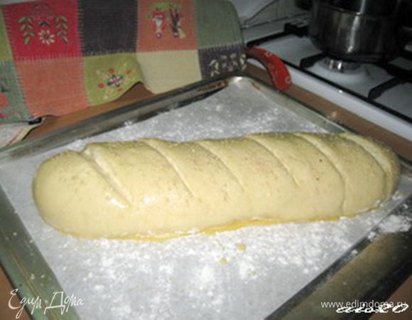 Сделать надрезы наискосок глубиной около 1 см, смазать заготовку взбитым желтком, при желании можно посыпать белым кунжутом. 
