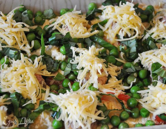 Уложить мясные шарики. Посыпать зеленым горошком запеканку. На каждый шар выложить немного тертого сыра. Посыпать резаным базиликом.