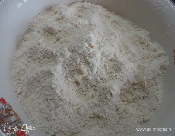Включить духовку для разогрева до 220 градусов. С апельсина натереть цедру и выжать сок с половины апельсина.
Высыпать муку с разрыхлителем в чашку, выложить масло и руками перетереть в масляную крошку.

