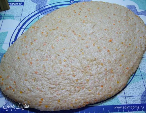 Распластать тесто на столе руками в виде овала.