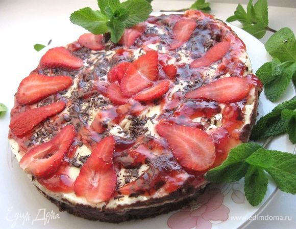 Вынуть из духовки, освободить от фольги. Дать постоять 1 час  при комнатной температуре. Аккуратно раскрепить борт формы. Постепенное охлаждение в значительной степени снижает риск появления на торте трещин. Украсить натертым с помощью овощечистки шоколадом, а также растопленным в  кастрюльке на слабом огне джемом, лепестками ягод клубники. 