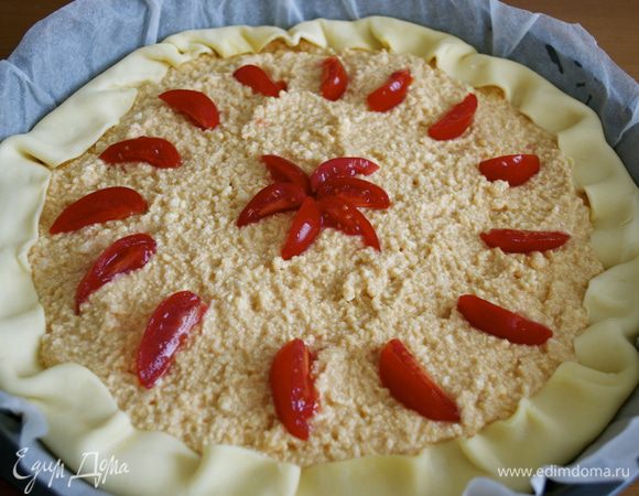 Завернуть края теста к центру. Помидорки-черри нарезать на четвертинки и украсить ими верх пирога. Поставить выпекаться в разогретую до 180 С духовку на 30-40 минут. 