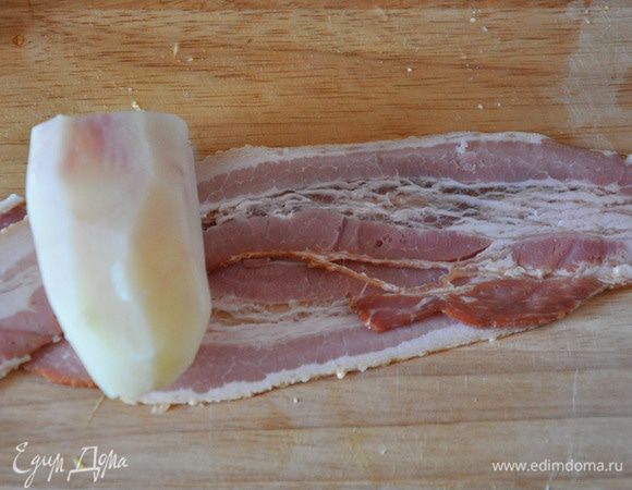 Картофель отварить в мундире до полуготовности, в подсоленной воде. Очистить. Каждый завернуть в 2 полоски бекона.