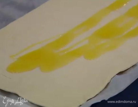 Противень выстелить бумагой для выпечки, выложить большую часть теста, сбрызнуть оливковым маслом.