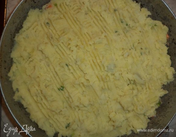 Сверху ровным слоем выложить картофельное пюре, разровнять и сделать вилкой на поверхности узоры.
Запекать 30 минут.