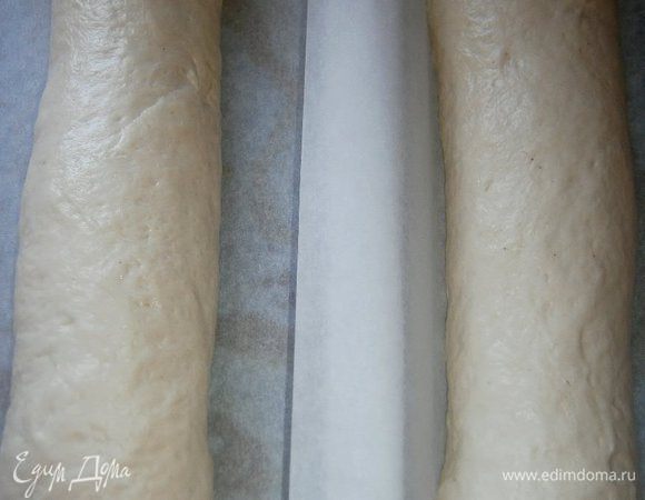 Выложить на противень, застеленный бумагой для выпечки. Накрыть плёнкой и оставить на 1,5 - 2 часа для подхода.