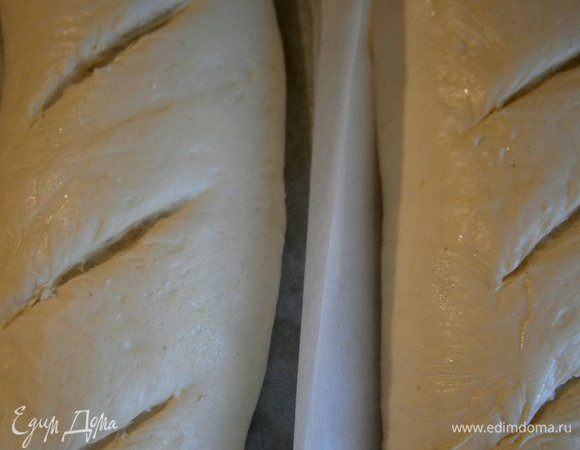 Духовку разогреть до t 200 С, поставить на дно духовки посуду с водой. На батонах сделать несколько надрезов. И выпекать в разогретой духовке 30 - 45 минут ( до золотистой корочки). За 10 минут до готовности, батоны вынуть,  сбрызнуть  водой и поставить обратно допекаться.