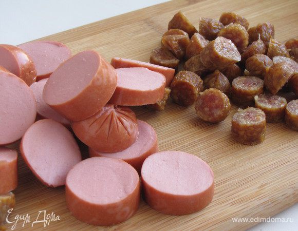 Нарезать сардельки и колбаски кружками толщиной 1 см.