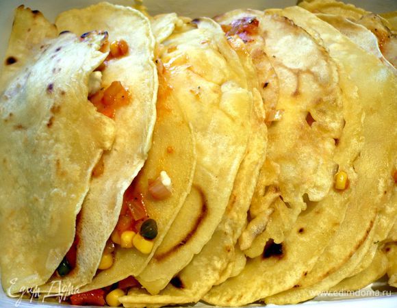 Моцареллу режем кружочками, по кружочку - для каждой лепешки. Смажем форму для запекания маслом. Выкладываем полумесяцы тортильи открытыми краешками вверх, в серединку выкладываем пару столовых ложек начинки и ломтик моцареллы. 