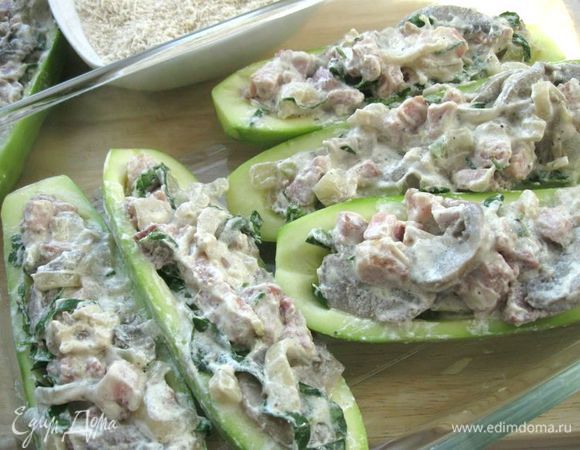 Разрезать кабачки  вдоль на половинки, вынуть серединки. Нафаршировать кабачки  начинкой. 
