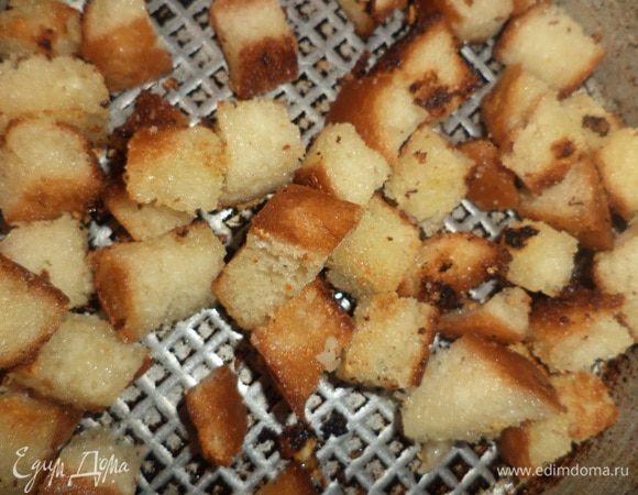 Хлеб нарезать кубиками, залить чесночным маслом, перемешать, оставить на 5 минут.
Поджарить сухарики до хрустящей корочки.