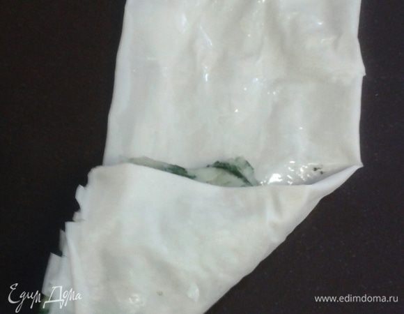 Поверх начинки загните угол, сформировав треугольник.