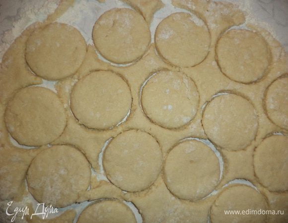 Тесто раскатать в пласт толщиной 0,5 см. Стаканом вырезать из теста кружочки. Выложить кружочки на смазанный маслом противень. Сверху кружочки слегка придавить вилкой. 