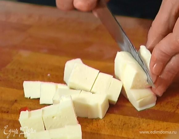 Моцареллу нарезать кубиками и выложить в сковороду к помидорам.