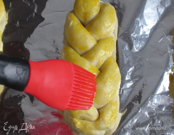 Яичный желток слегка взбить вилкой. Выложить булочки на противень с пергаментом или фольгой, смазать яичным желтком.