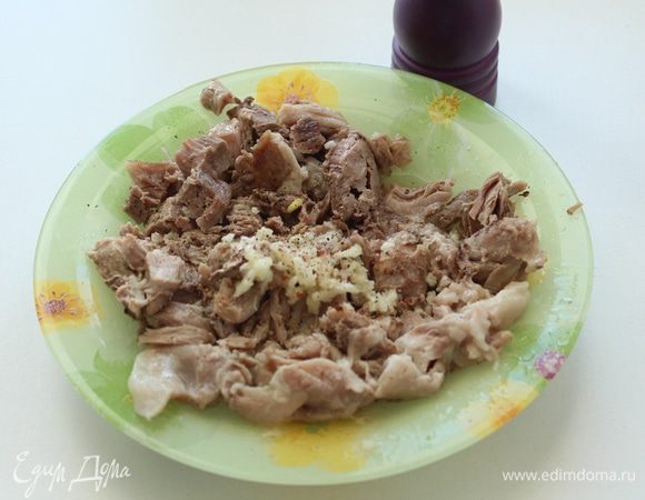 Мясо разобрать на кусочки, добавить молотый перец, выдавить чеснок.