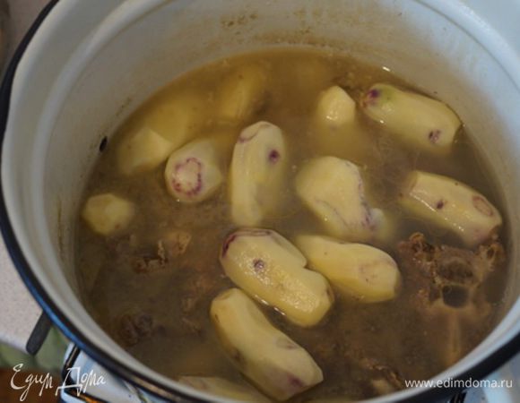 Когда бульон почти готов, закладываем картофель целый в эту же кастрюлю и варим дальше. 