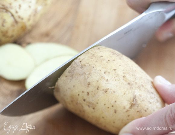 Картофель, не очищая, порезать кружками, сбрызнуть оставшимся растительным маслом, посолить, разложить вокруг курицы.