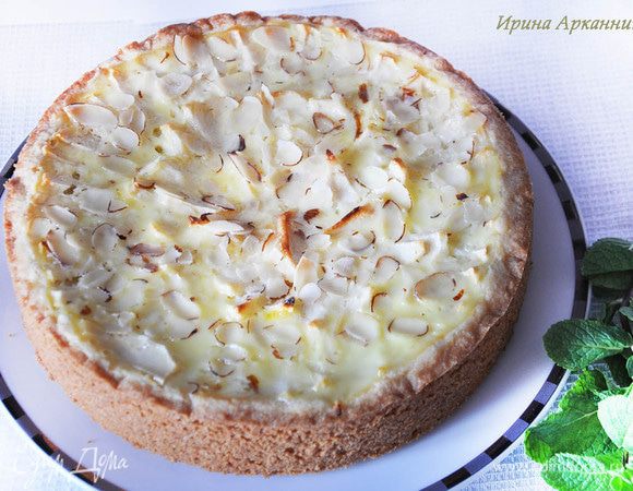 Яблоки нарезать тонкими ломтиками, вырезав серединку с косточками. Выложить в форму по спирали. Смешать в миске остальные ингредиенты начинки, кроме сахара. Вылить на яблоки. Посыпать сахаром и миндалем. Выпекать около 50 минут.