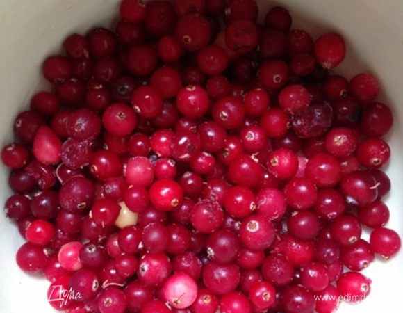 За это время займемся соусом.
Кладем клюкву (у меня замороженная) в эмалированную кастрюльку, вливаем лимонный сок, коньяк и воду, сыплем сахар.