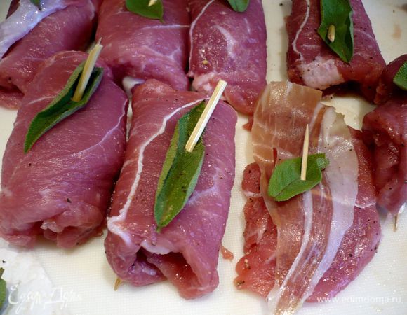 Вот так выглядит более распространенный вариант салтимбокка. На кусочек мяса выкладываем сначала ломтик пармской ветчины, затем два листика шалфея и закрепляем их зубочистками. Так как я очень люблю жареный шалфей, то просто не сумела спрятать весь шалфей внутрь рулетика, а положила лишь один листик внутрь, а другой прикрепила сверху так, чтобы и сам рулетик не разворачивался.