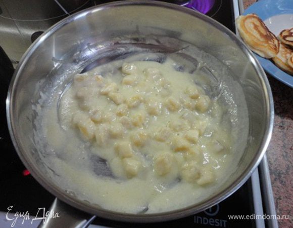 3. На среднем огне растопить сливочное масло в сковороде, добавить сахарную пудру и, помешивая, готовить пару минут, до золотистого цвета. Я не додержала и крем не получился золотистым. Добавить сметану и бананы. Тушить 1 минуту.