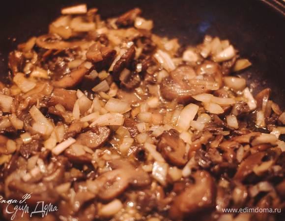 Разогреваем сковороду с оливковым маслом/либо растительным. На разогретую сковороду выкладываем грибы шампиньоны (я брала в упаковке замороженные шампиньоны, перед тем как выкладывать я их разморозила. Можно нарезать и свежие грибочки шампиньоны) + лук + чеснок (нарезанные). Пережариваем все, перчим, солим. 