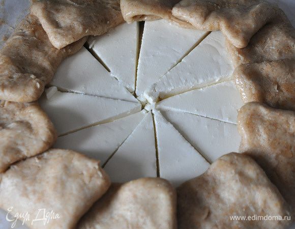 Выложить по кругу сыр. Залепить края теста.