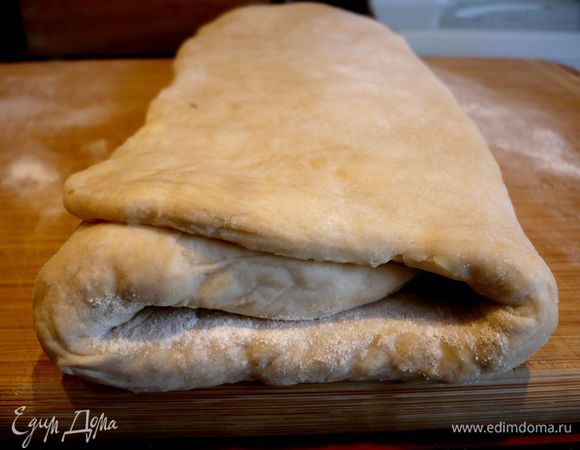 Достаем наше тесто и раскатываем его в прямоугольный пласт. Сворачиваем тесто по удлиненной стороне так, как показано на фото, дважды.