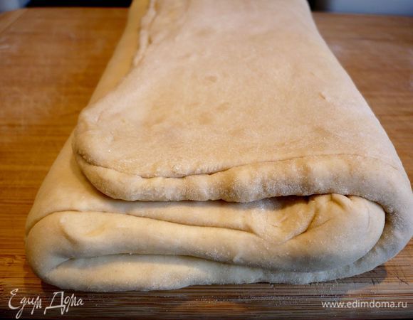 Достаем тесто. Раскатываем его на присыпанной мукой поверхности в не очень тонкий пласт, снова сворачиваем дважды. 
