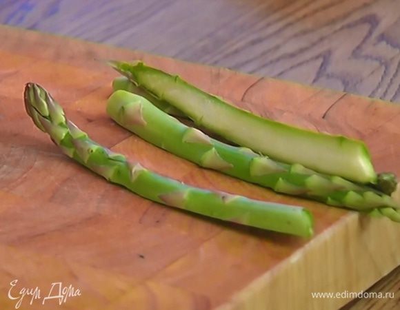 У спаржи удалить грубые черенки и разрезать ее вдоль пополам.