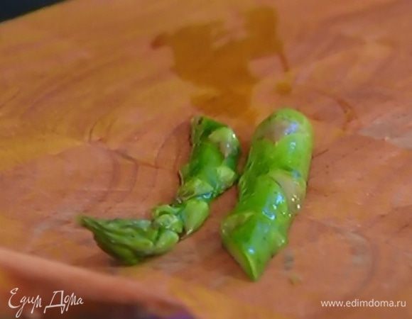 Стебли спаржи разрезать на две части.