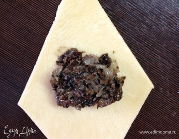 На середину ромбика кладем чайную ложку начинки, соединяем противоположные концы и защипываем.
